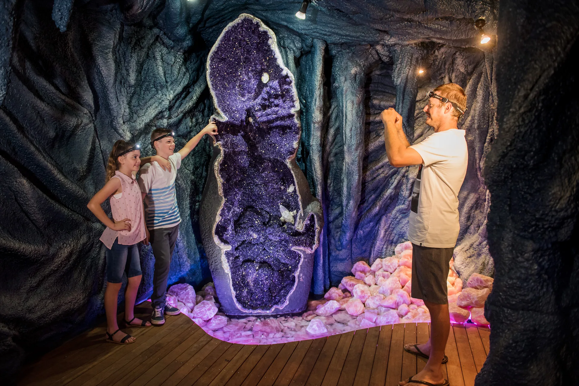 A family beside the world's largest amethyst geode at Crystal Caves